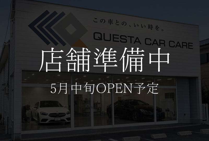 Storefront with large overlay text in Japanese: '店舗準備中' and '5月中旬OPEN予定' at a car care shop, showing cars inside through glass doors.